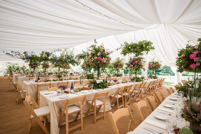 dorset wedding marquee Long tables, folding chairs and coconut matting
