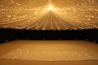 dorset wedding White dance floor, black walls and fairy light canopy
