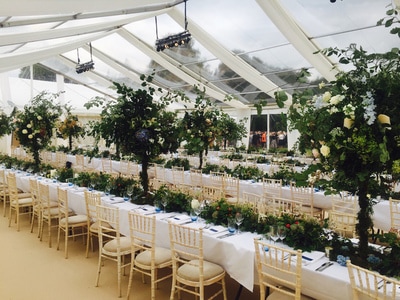 dorset wedding marquee with trestle tables, floral centrepieces, clear roofs and hanging spotlights