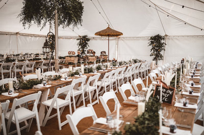 dorset wedding marquee with rustic wooden tables and white folding chairs